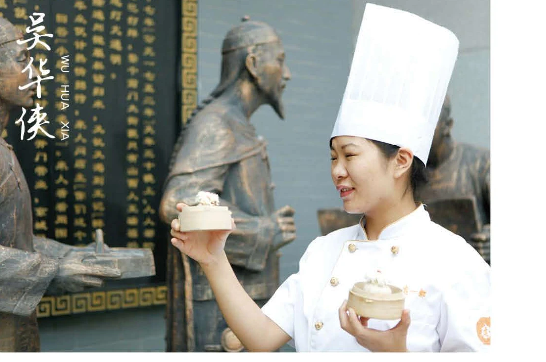 吴华侠, eighth-generation master of the Duyichu shaomai craft, presenting shaomai before the bronze of the Qianlong Emperor.