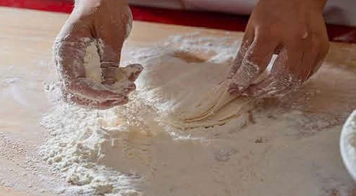 Lacing the wrapper's edge into the lotus-leaf 荷叶边 rim.